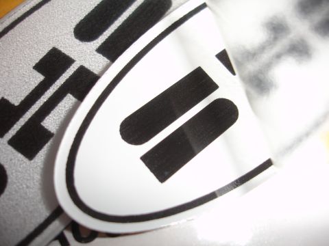 1990 Ford Taurus - Close-up of a white oval emblem with black stripes, possibly a vehicle badge.