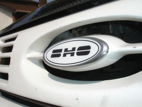 1990 Ford Taurus - Close-up of the SHO emblem on a Ford Taurus grille.