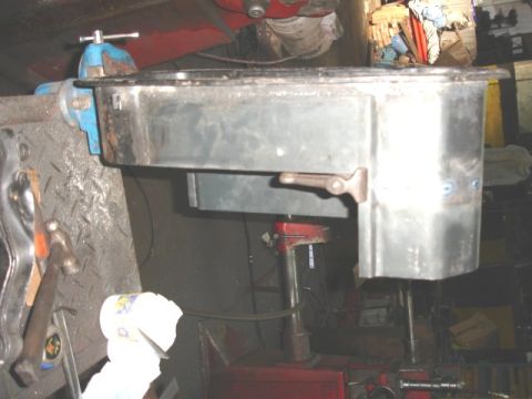 1980 Ford Bronco - An oil pan is secured in a vise, indicating it is being worked on or repaired.