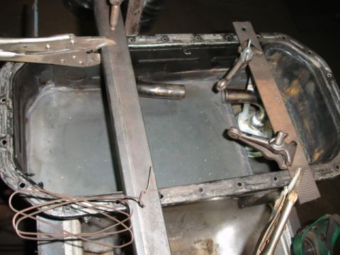 1980 Ford Bronco - Close-up of an oil pan with various tools attached for repair or modification.