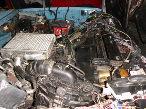 1980 Ford Bronco - Engine bay with extensive wiring and an intercooler, suggesting modifications or repairs. The Supermotors.net logo is present.