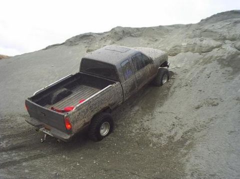 1984 Chevrolet Blazer - A four-door pickup truck navigates a muddy incline.