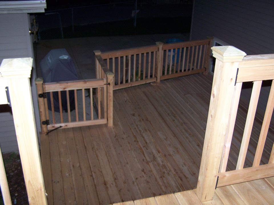 Wooden deck with a covered grill and railings. A "SUPERMOTORS" watermark is visible