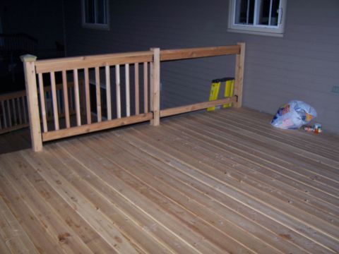1986 Ford Bronco - A newly constructed wooden deck features a railing, a yellow ladder, and a bag of trash near the house.
