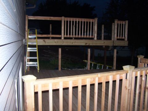 1986 Ford Bronco - A wooden deck is under construction, with a ladder providing access to the upper level.