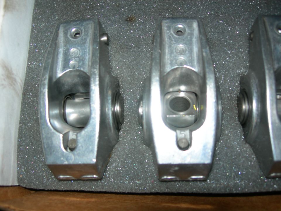 Two aluminum rocker arms with visible stamping