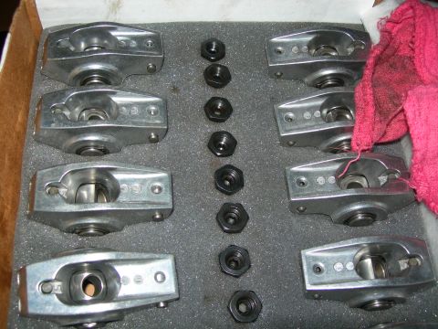 1984 Ford Bronco - A set of eight aluminum roller rocker arms are laid out in a gray foam-lined box next to a stack of black nuts. A pink rag is visible in th…