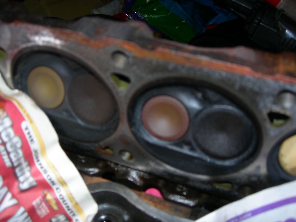 Close-up of engine cylinder head combustion chambers with valves visible.