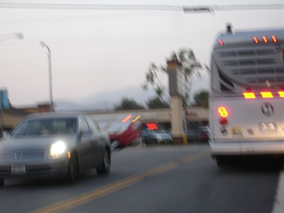 Silver sedan with headlights on, seen from the front