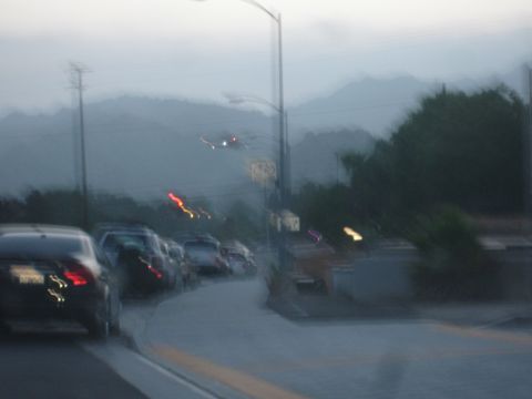 1993 Ford Taurus - A blurry scene captures multiple vehicles on a road during twilight, with mountains visible in the distance.