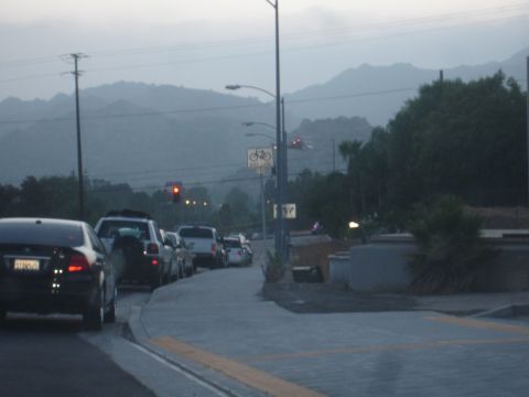 1993 Ford Taurus - A line of vehicles is stopped in traffic on a road with a hazy mountain range visible in the distance.