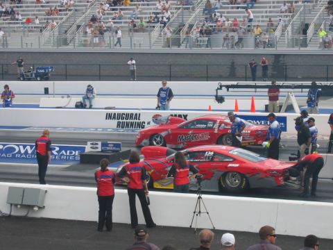 1992 Ford Mustang - Drag cars prepare for a race at a drag strip with spectators watching from the stands.