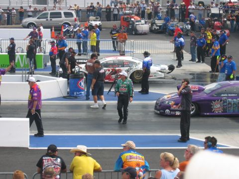 1992 Ford Mustang - Drag strip scene with multiple race cars and crew members preparing for a race.
