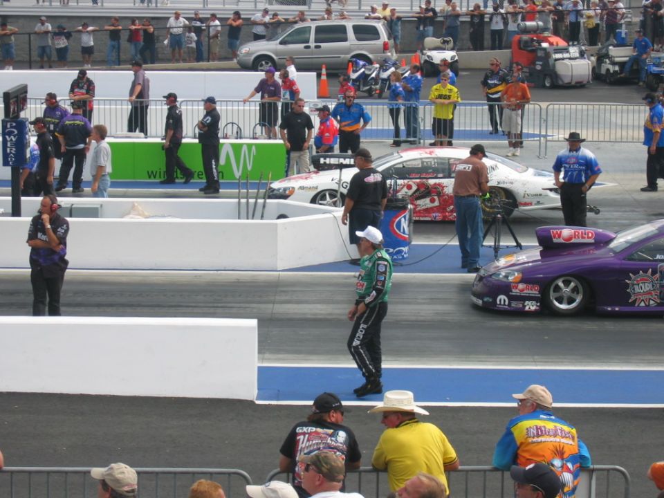 Drag racing scene with a purple drag car and a white drag car