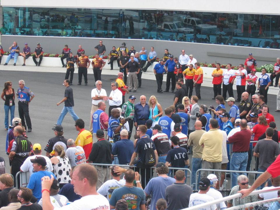 People gathered on a paved area with a building in the background