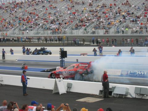 1992 Ford Mustang - A drag racing car, identified by its 'Quick Lane' sponsorship, generates a large cloud of smoke as it races down the track.