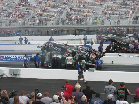 1992 Ford Mustang - Drag racing cars and crews on the track at an event with spectators in the background.