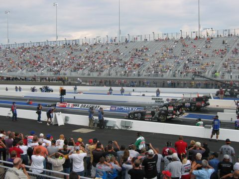 1992 Ford Mustang - Drag racing cars line up on the track as spectators fill the grandstands.