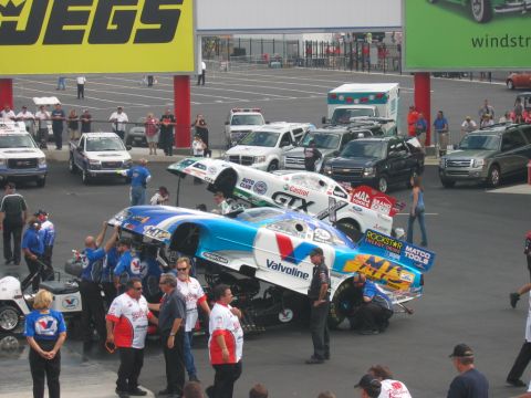 1992 Ford Mustang - Crews work on drag racing cars at an event. The cars are highly customized for speed.