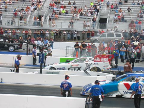 1992 Ford Mustang - Drag racing cars line up on the track with spectators in the stands.