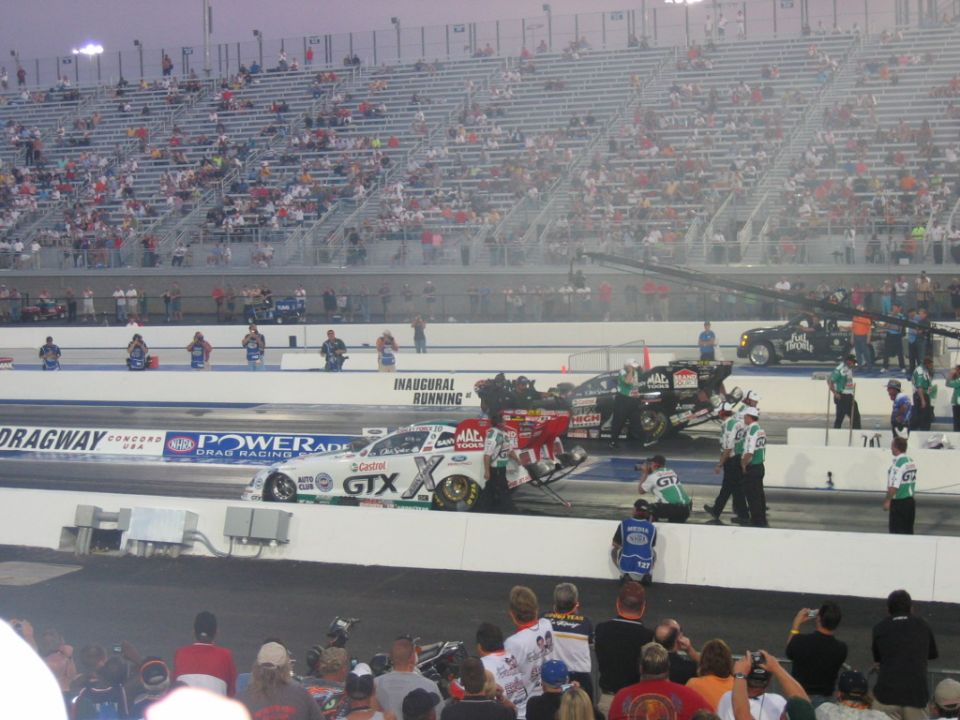 Drag racing cars at the starting line with spectators in the stands