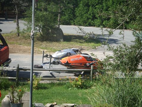 1995 Ford Mustang - Two jet skis are parked on a trailer, ready for transport on a sunny day.