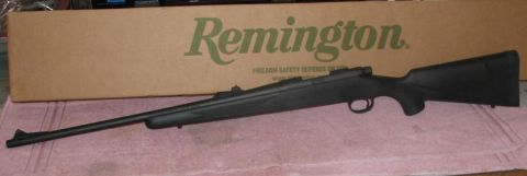 1991 Ford Bronco - A black Remington rifle is displayed on a pink towel, with its original cardboard box in the background.