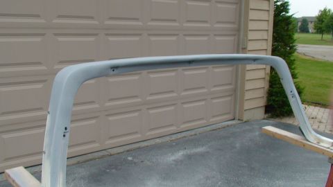 1979 Ford Bronco - A gray metal roll bar section is shown in front of a garage door, possibly for a classic SUV.