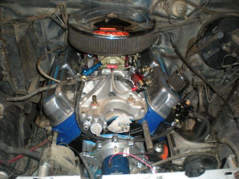 1985 Ford Bronco - Close-up view of a modified V8 engine, a chrome air cleaner, polished intake manifold, and blue valve covers.