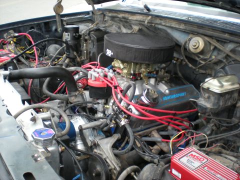 1985 Ford Bronco - Close-up of a V8 engine bay with aftermarket performance parts installed.
