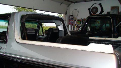 1979 Ford Bronco - The side view of a 1978 Ford Bronco shows its interior and the exterior of a second vehicle parked behind it in a garage.