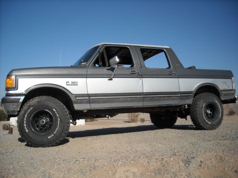 1990 Ford C-150 (Centurion Conversions) - This lifted Ford Bronco features a two-tone paint job and off-road tires.