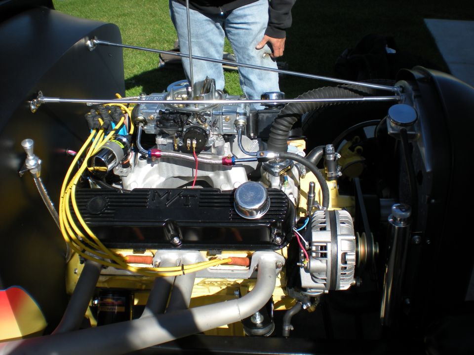 Engine bay with V8 engine, chrome carburetor, and yellow spark plug wires