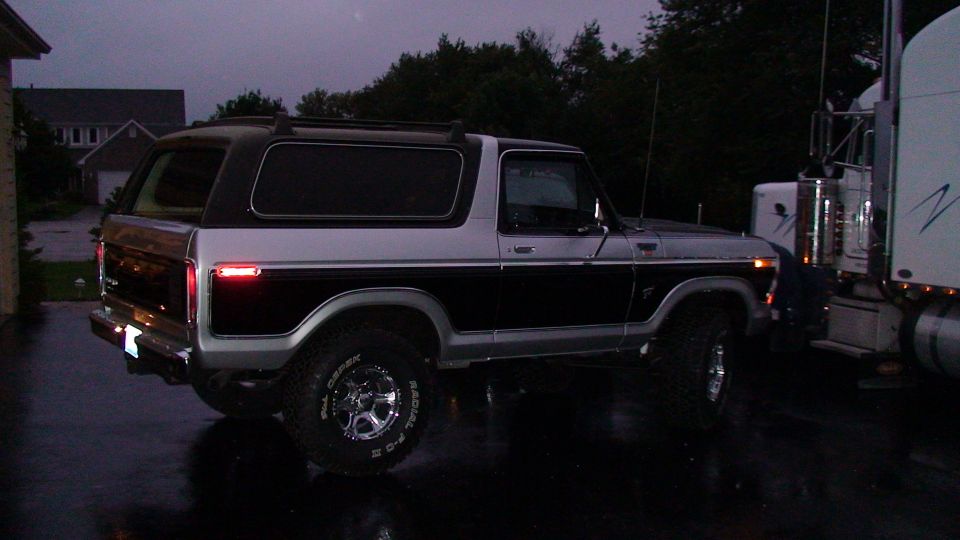 Ford Bronco parked next to a semi-truck