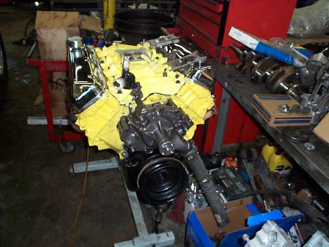 1978 Ford Bronco - V8 engine on a stand, likely undergoing rebuild or modification in a garage setting.