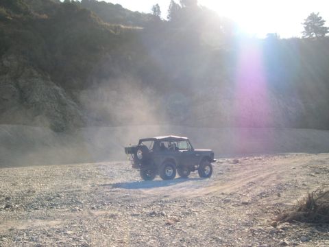 2007 Toyota FJ Cruiser - A dark-colored SUV kicks up dust as it drives along a rocky, off-road path.