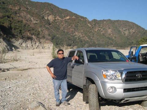 2007 Toyota FJ Cruiser - A man stands by his silver Toyota Tacoma truck in a dry, rocky canyon with mountains in the background.