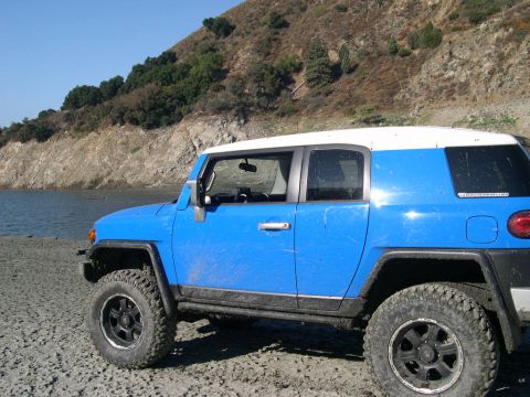 2007 Toyota FJ Cruiser - Blue 2007 Toyota FJ Cruiser parked on a dirt shore with a rocky hillside in the background.