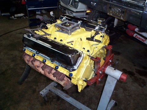 1978 Ford Bronco - Engine on stand, likely undergoing rebuild or modification, with yellow block and chrome valve covers visible.