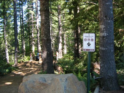 2005 Jeep Wrangler - A Jeep Wrangler is parked on a dirt path in a wooded area, near a sign indicating trail information.