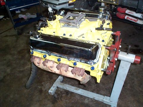 1978 Ford Bronco - A V8 engine, painted yellow with chrome accents, is mounted on an engine stand for maintenance.