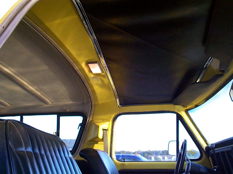 Black padded headliner and yellow interior of a removable-hardtop truck cab from inside