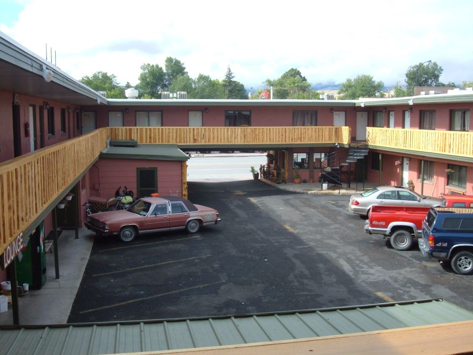 Brown sedan parked in front of a motel.