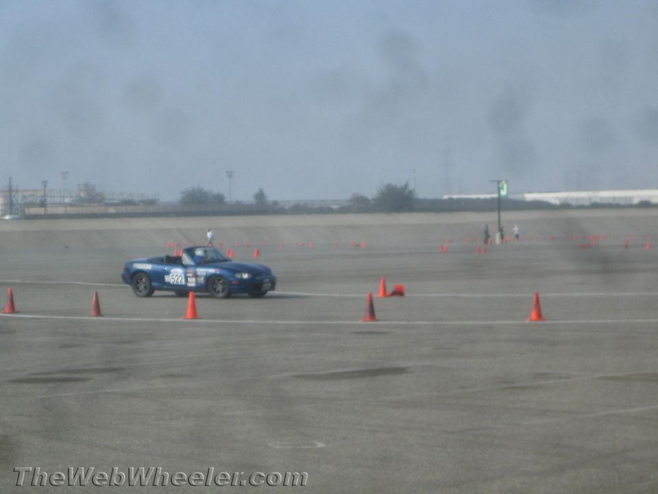 Blue Mazda Miata convertible with number 522 on track with cones.