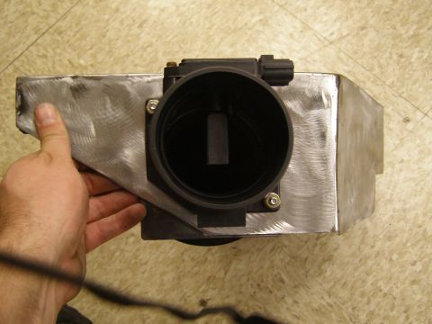2003 Ford Crown Victoria - A person's hand holds a custom metal intake box with a black sensor housing attached. The intake box appears to be a modification for a veh…