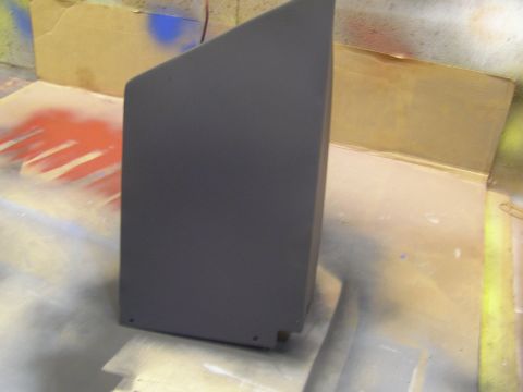 2003 Ford Crown Victoria - A dark gray, angular object is shown in a workshop setting with spray paint splatters on the floor and background.