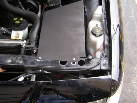 2003 Ford Crown Victoria - A close-up view of the engine bay of a 2003 Ford Crown Victoria, focusing on the air intake system and windshield washer fluid reservoir.