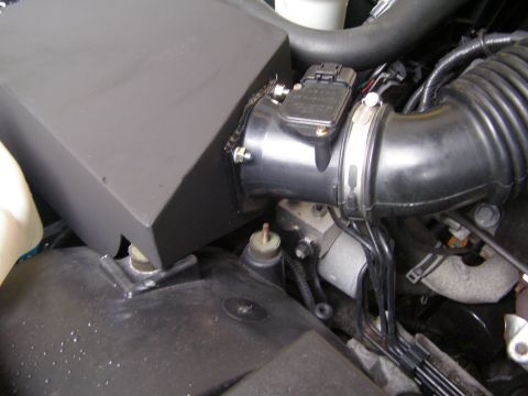 2003 Ford Crown Victoria - A close-up view of the engine bay of a 2003 Ford Crown Victoria, focusing on the air intake system. Visible components include the air filt…