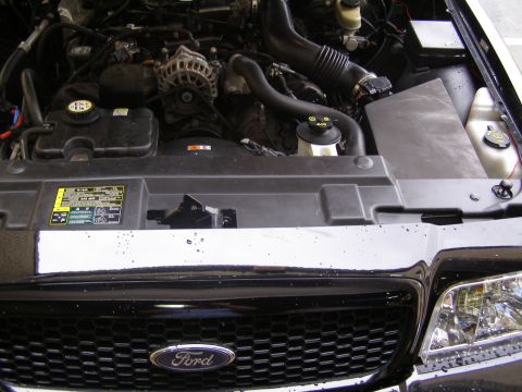2003 Ford Crown Victoria - The engine bay of a 2003 Ford Crown Victoria is shown, including the grille and air intake system.