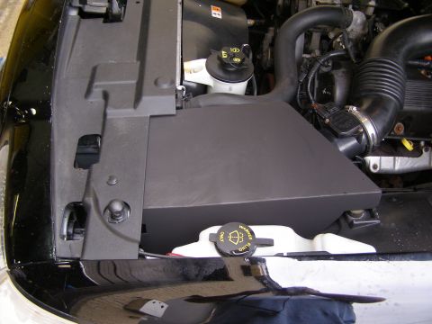 2003 Ford Crown Victoria - Close-up view of a black cold air intake box and associated engine parts.